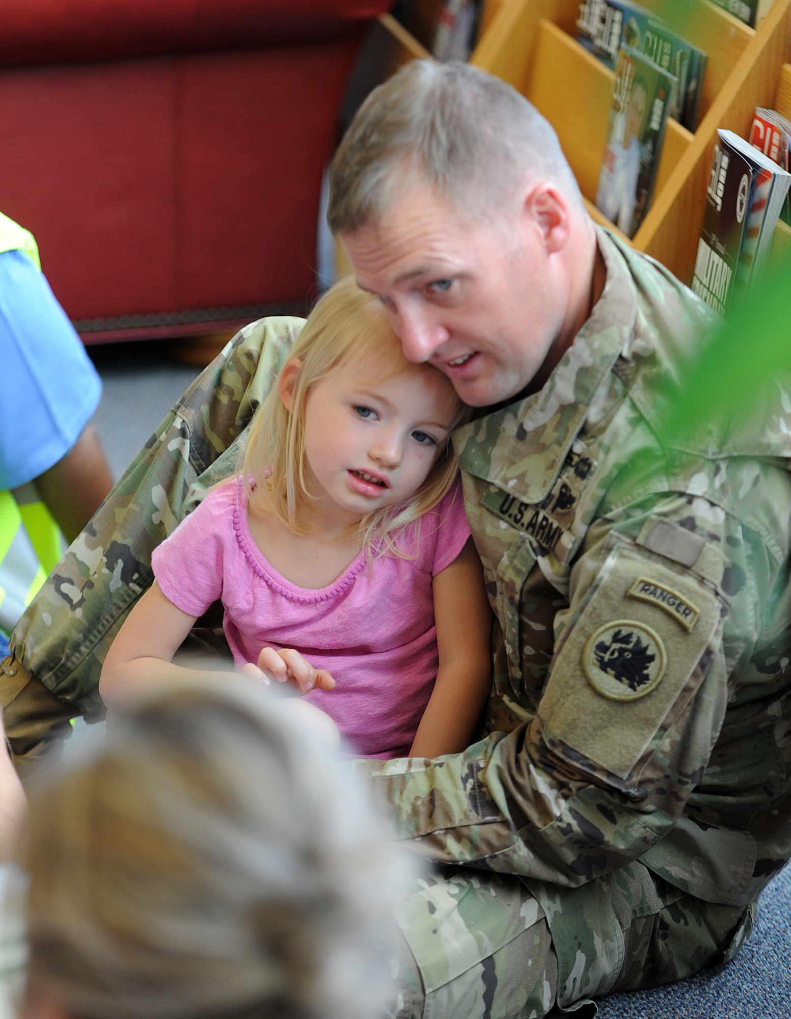 Capt. Chris Pulliam, 121st Infantry, Company H commander, and his daughter Morgan Pulliam, 3, enjoy a story time book reading at the base library.  Month of the Military Child story time will be held April 13 at 10 a.m. (U.S. Air Force photo by Tommie Horton)