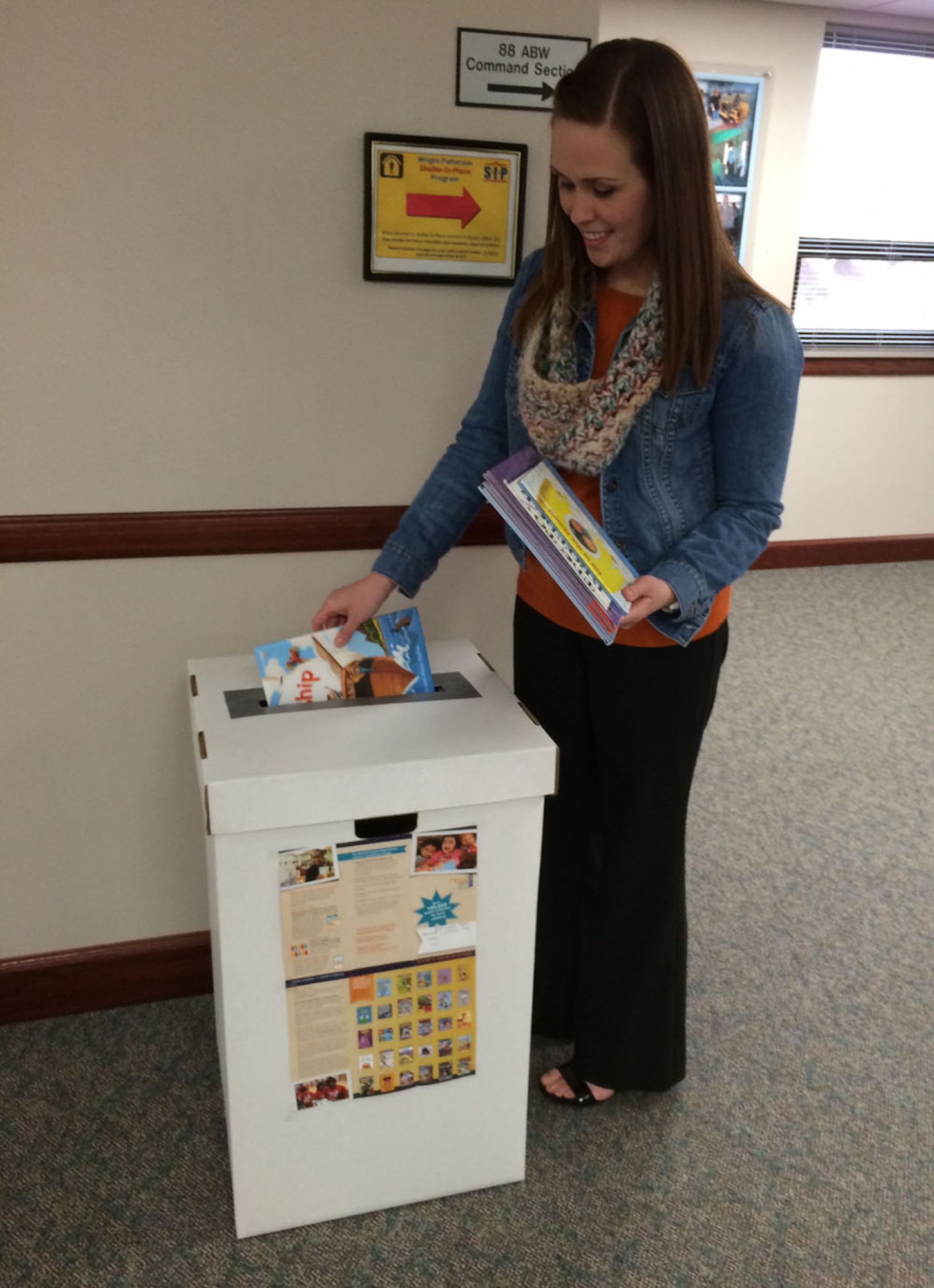 Jennifer Bauer contributes books for the Read On! Dayton Region book drive. Collection boxes have been distributed to 15 high-traffic points around the base, and the books will be collected until April 15. (U.S. Air Force photo/James Tyler)
