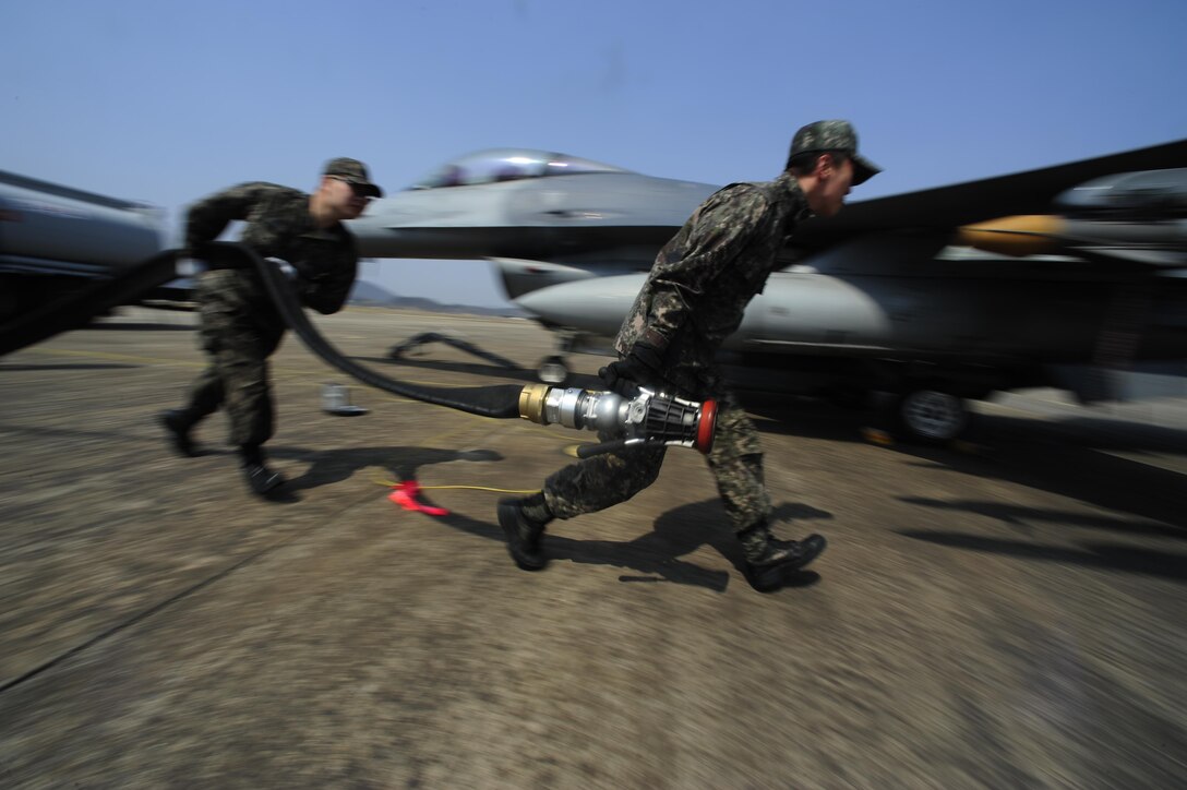 Republic of Korea air force Airman 1st Class Chang Kyu Park and Staff Sgt. Heon Kyun Jeon, both from the 19th Fighter Wing, carry aircraft equipment during Buddy Wing 16-3 at Jungwon Air Base, Republic of Korea, March 30, 2016. Buddy Wing training, held multiple times a year, polishes the ability of the Republic of Korea air force and U.S. Air Force Airmen to train and operate as a combined force. (U.S. Air Force photo by Staff Sgt. Nick Wilson/Released)
