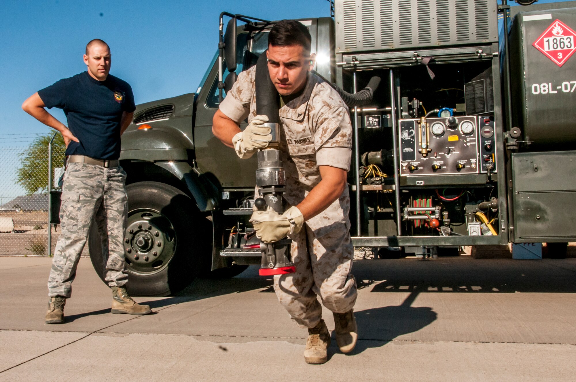 TUCSON, Ariz. -- Under the watchful eye of Air Force Staff Sgt. Scott Frank, Marine Corps Lance Cpl. Paul Robledogarcia, a bulk fuel specialist from Bulk Fuel Company Alpha, 6th Engineer Support Battalion – home-based out of Davis-Monthan Air Force Base, practices pulling a fuel hose out of a tanker. Franks said that eventually fuels specialist would hand the nozzle to a crew chief, later ensuring that a proper connection to the aircraft is made, eliminating the possibility of fuel leaks. Beginning in late March and ending in early June, the Marines will be training and executing operational tasks at the 162nd Wing. (U.S Air National Guard Photo by Tech. Sgt. Erich B. Smith)