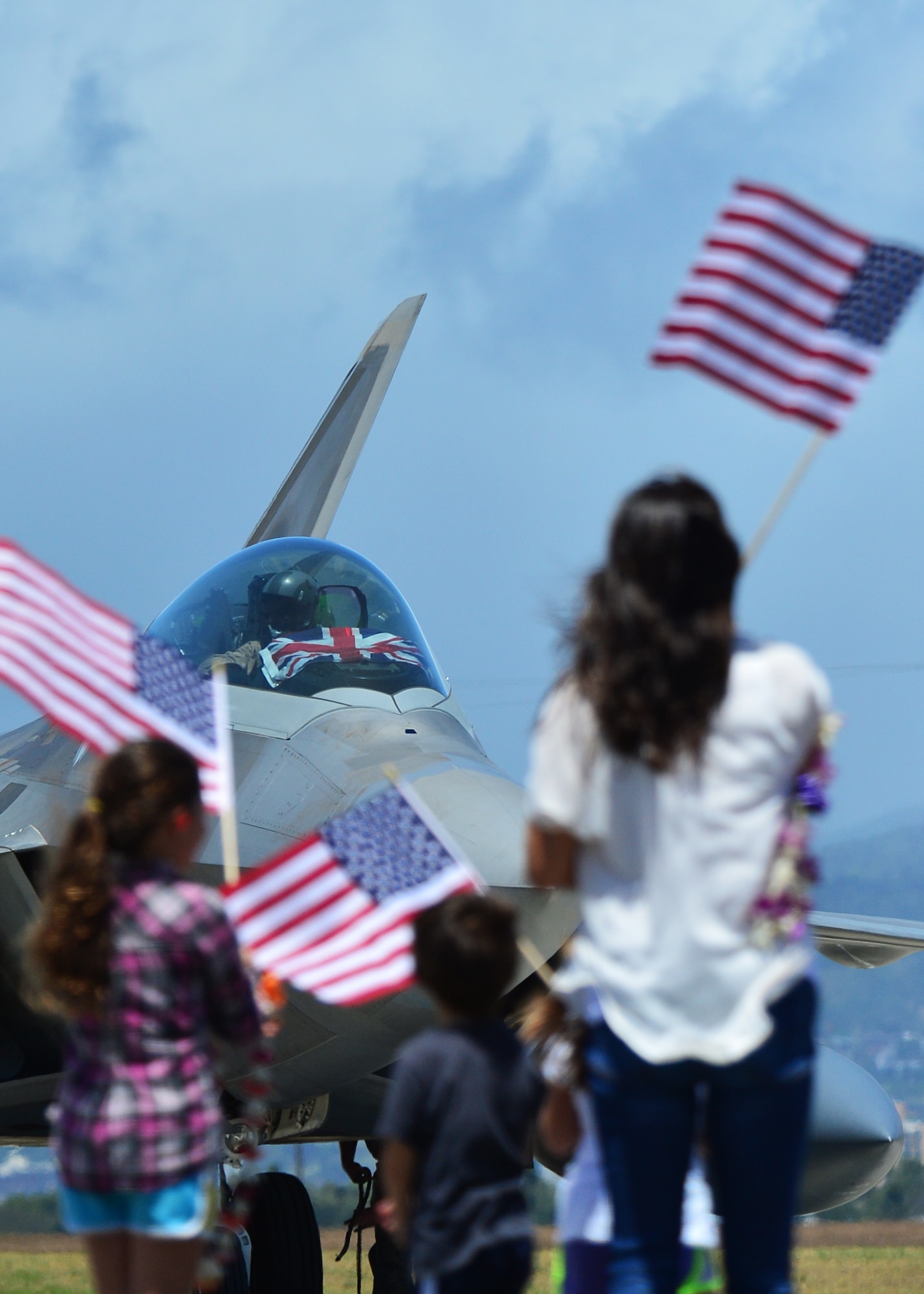 An F-22 Raptor pilot, from the Hawaiian Raptors, runs the shutdown check list as his family waits to great him for the first time in six months, on Joint Base Pearl Harbor-Hickam, April 8, 2016. The pilot was deployed to the Central Command area of responsibility with the Hawaiian Raptors. The Hawaiian raptors are made up of F-22 pilots from the 199th Fighter Squadron and the active-duty 19th Fighter Squadron and are supported by the Hawaii Air National Guard’s 154th Maintenance Squadron and the active-duty 15th Maintenance Squadron. This marked the first operational deployment for the Hawaiian Raptors. (U.S. Air Force photo by Tech. Sgt. Aaron Oelrich/released)
