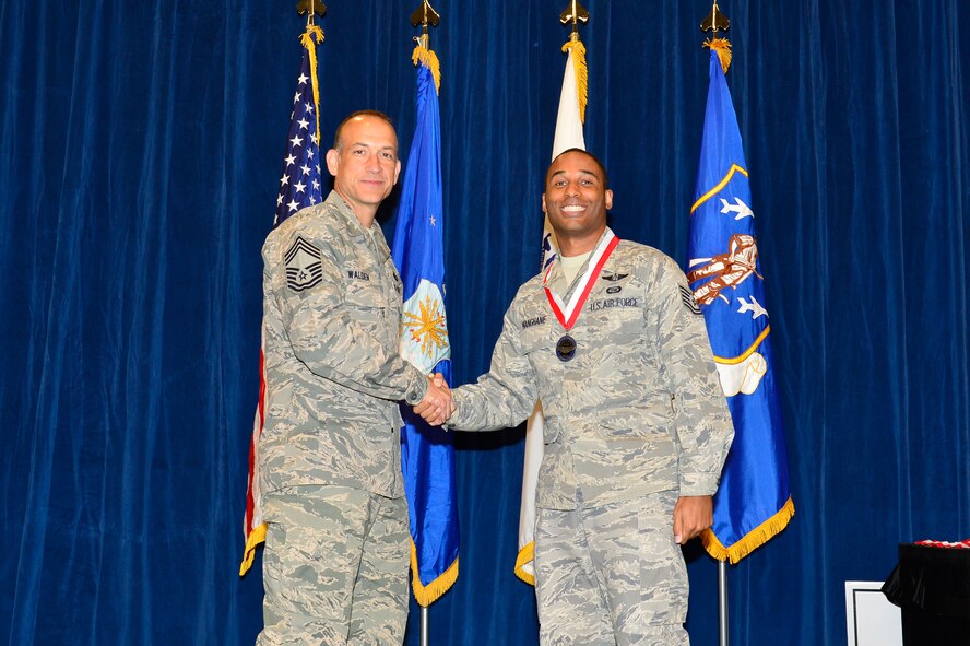 MCGHEE TYSON AIR NATIONAL GUARD BASE, Tenn. -  Tech. Sgt. Samuel Manghane, right, receives the Distinguished Graduate medallion from Chief Master Sgt. Edward L. Walden Sr., commandant of the Paul H. Lankford Enlisted PME Center, here, March 30, 2016, at the I. G. Brown Training and Education Center. (U.S. Air National Guard photo by Master Sgt. Jerry D. Harlan/Released)