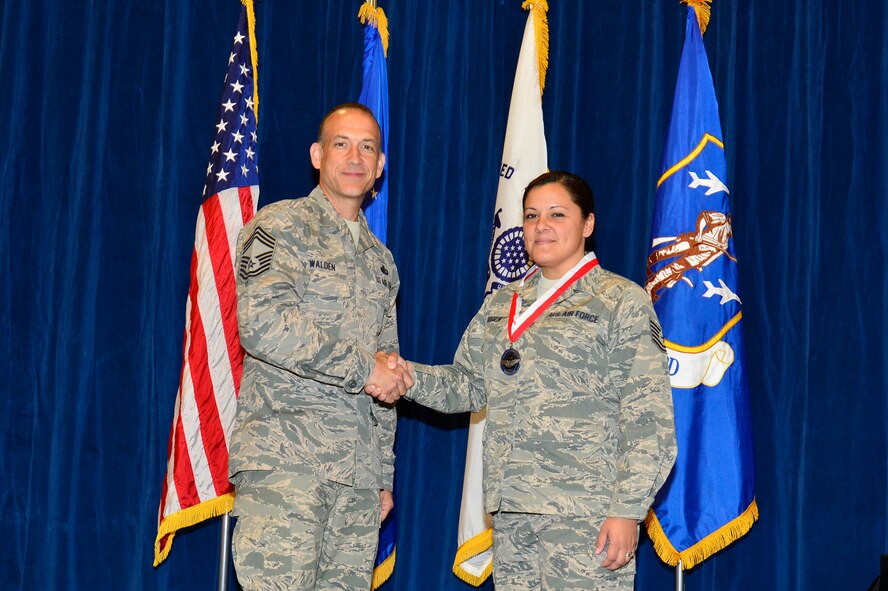 MCGHEE TYSON AIR NATIONAL GUARD BASE, Tenn. -  Tech. Sgt. Misty Goodrick, right, receives the Distinguished Graduate medallion from Chief Master Sgt. Edward L. Walden Sr., commandant of the Paul H. Lankford Enlisted PME Center, here, March 30, 2016, at the I. G. Brown Training and Education Center. (U.S. Air National Guard photo by Master Sgt. Jerry D. Harlan/Released)