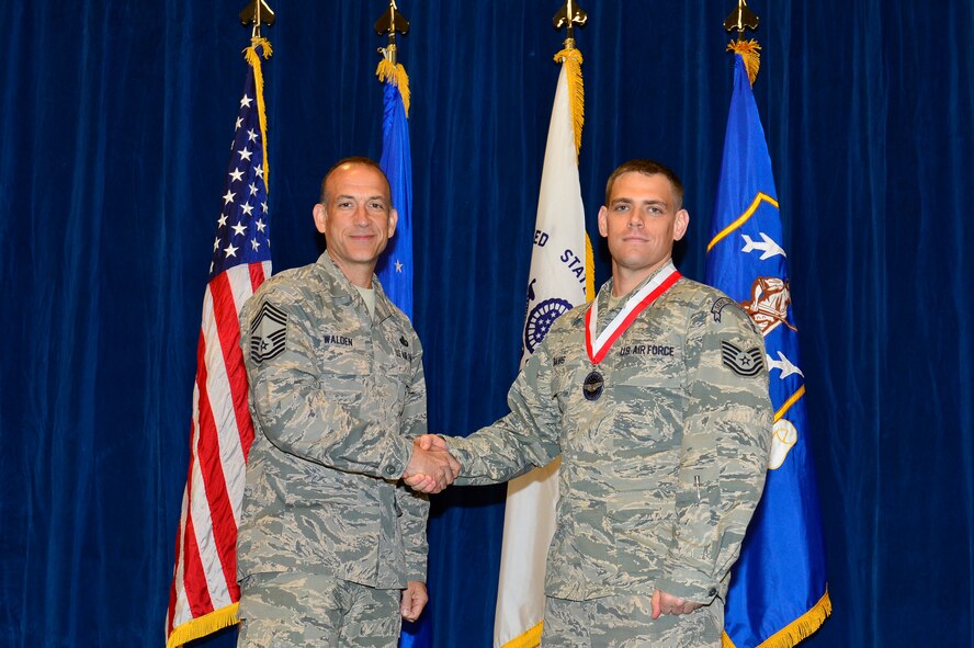 MCGHEE TYSON AIR NATIONAL GUARD BASE, Tenn. - Tech. Sgt. Jason Davis, right, receives the Distinguished Graduate medallion from Chief Master Sgt. Edward L. Walden Sr., commandant of the Paul H. Lankford Enlisted PME Center, here, March 30, 2016, at the I. G. Brown Training and Education Center. (U.S. Air National Guard photo by Master Sgt. Jerry D. Harlan/Released)