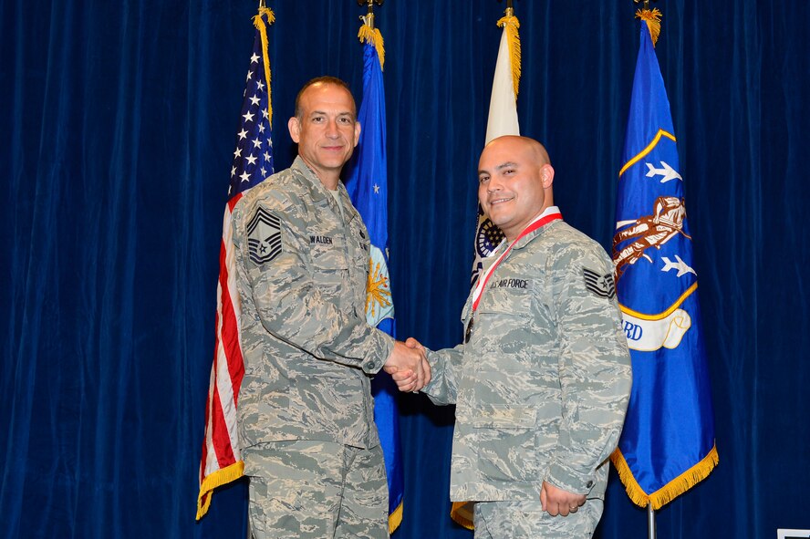 MCGHEE TYSON AIR NATIONAL GUARD BASE, Tenn. -  Tech. Sgt.  Daniel Olmeda, right, receives the Distinguished Graduate medallion from Chief Master Sgt. Edward L. Walden Sr., commandant of the Paul H. Lankford Enlisted PME Center, here, March 30, 2016, at the I. G. Brown Training and Education Center. (U.S. Air National Guard photo by Master Sgt. Jerry D. Harlan/Released)