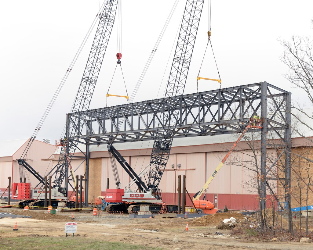 Crane operators from subcontractor CCS Constructors Inc., Morissville, Vt., lift an 80 ton truss into position, Pease Air National Guard Base, N.H., April 8, 2016. The construction project remodels Hangars 253 and 254 to maximize the operational space in order to promote efficiency and productivity in preparation for the arrival of 12 KC-46A tankers in February 2018. (U.S. Air National Guard photo by Staff Sgt. Curtis J. Lenz)