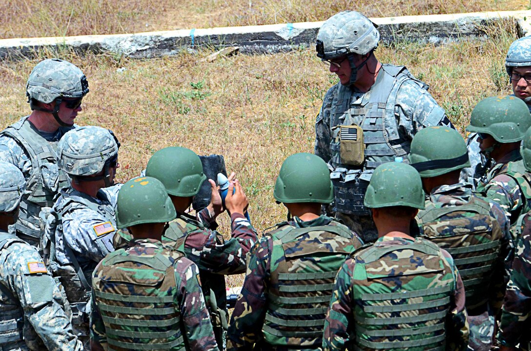 Soldiers from Headquarters and Headquarters Company, 2nd Battalion, 3rd Infantry Regiment, 1-2 Stryker Brigade Combat Team, instruct Filipino soldiers from 3rd Battalion, 7th Infantry Division, Armed Forces of the Philippines, on the proper procedures for hanging a mortar round during combined training at Fort Magsaysay, Philippines, April 7, 2016. The U.S. Soldiers were in the Philippines to take part in Balikatan 16, an annual training exercise intended to enhance military-to-military relations and combined combat capabilities.