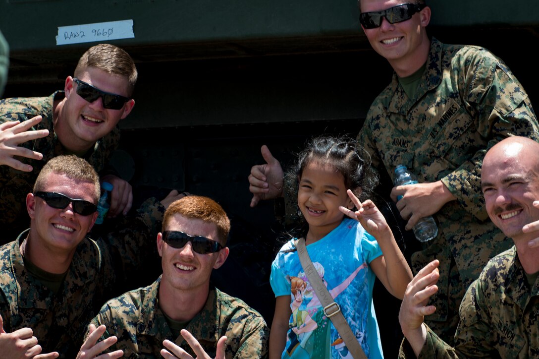 U.S. Marines with Fox Company, 2nd Battalion, 14th Marine Regiment pose for a photo with local Philippine school children during a static display at Clark Air Base, Philippines, April 9, 2016. As part of Balikatan 16, U.S. military and Armed Forces of the Philippines hosted a static display showcasing various aircraft from all U.S. services and the Philippine Air Force. Balikatan provides opportunities for U.S. and Philippine forces to learn from each other and train for potential real world crises, better preparing them to support the local population throughout the Indo-Asia-Pacific region. 