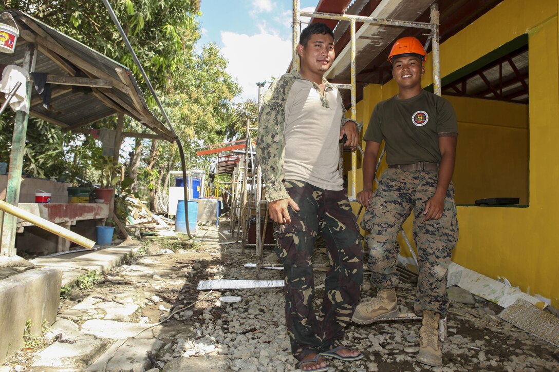 Philippine army soldier Pfc. Angelo Faegane, left, assigned to 552 Engineer Construction Battalion and U.S. Marine Corps Cpl. Lance Escobar, assigned to 9th Engineer Support Battalion, pause for a photo during a Humanitarian Civic Assistant (HCA) project at Matangharon Elementary School in Iloilo, Philippines, as part of Exercise Balikatan 2016, April 9, 2016. The construction project is one of multiple HCAs taking place during this year's exercise, designed to improve the quality of life for the local populace and strengthen the bond between our two nations. Balikatan, which means "shoulder to shoulder" in Filipino, is an annual bilateral training exercise aimed at improving the ability of Philippine and U.S. military forces to work together during planning, contingency and humanitarian assistance and disaster relief operations. 