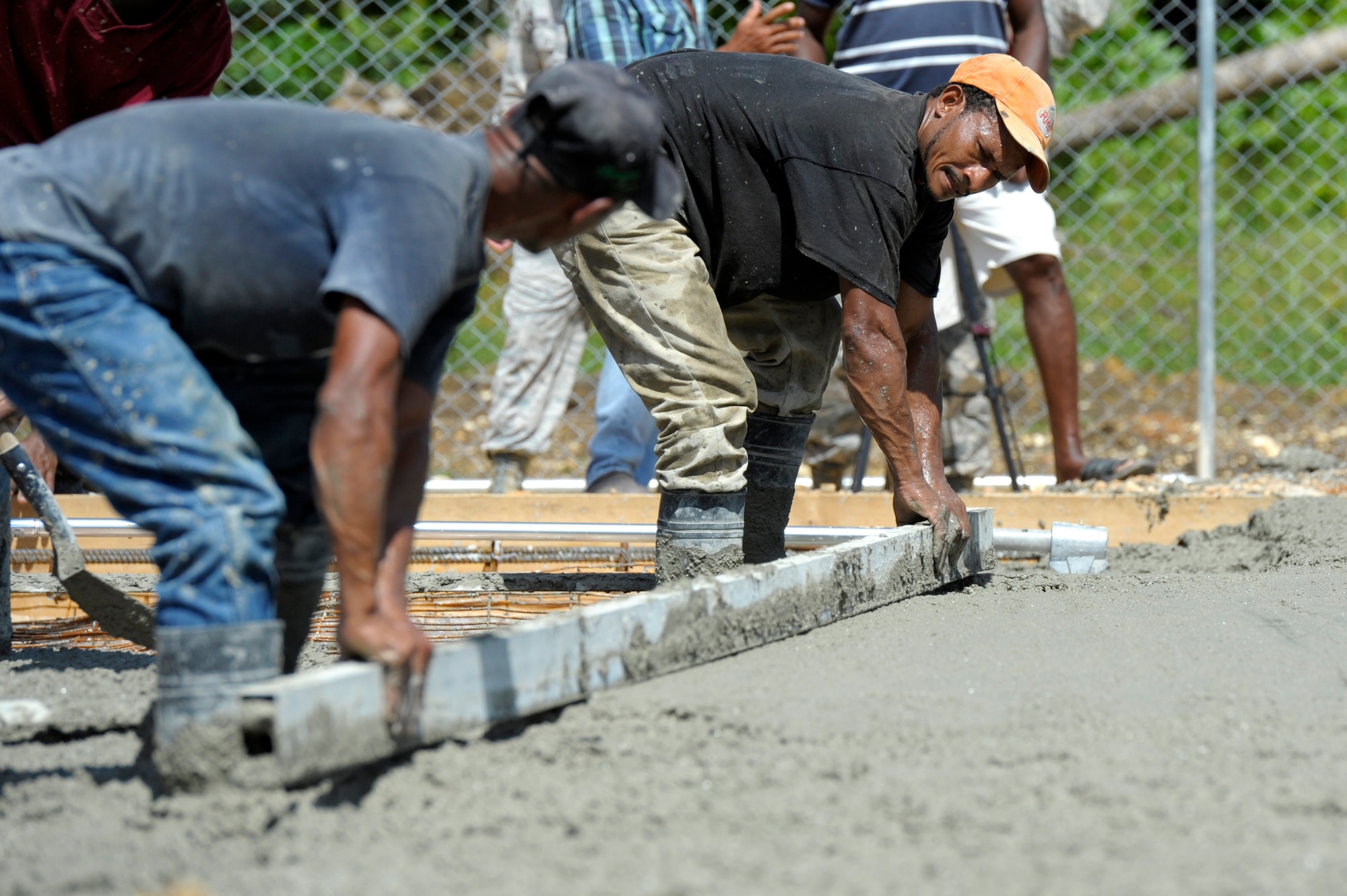 Dominican contractors level and smooth out the new concrete to create the foundation for a new clinic in Copeyito, Dominican Republic as part of Exercise NEW HORIZONS 2016, Apr. 7, 2016. NEW HORIZONS enhances U.S. military training and readiness by giving military civil engineers and medical professionals an opportunity to hone their craft and train for humanitarian assistance or disaster relief situations. Members of the 820th RED HORSE Squadron, from Nellis Air Force Base, Nevada, provide Quality Control and Quality Assurance during the foundation preparation. (U.S. Air Force photo by Master Sgt. Chenzira Mallory/Released)