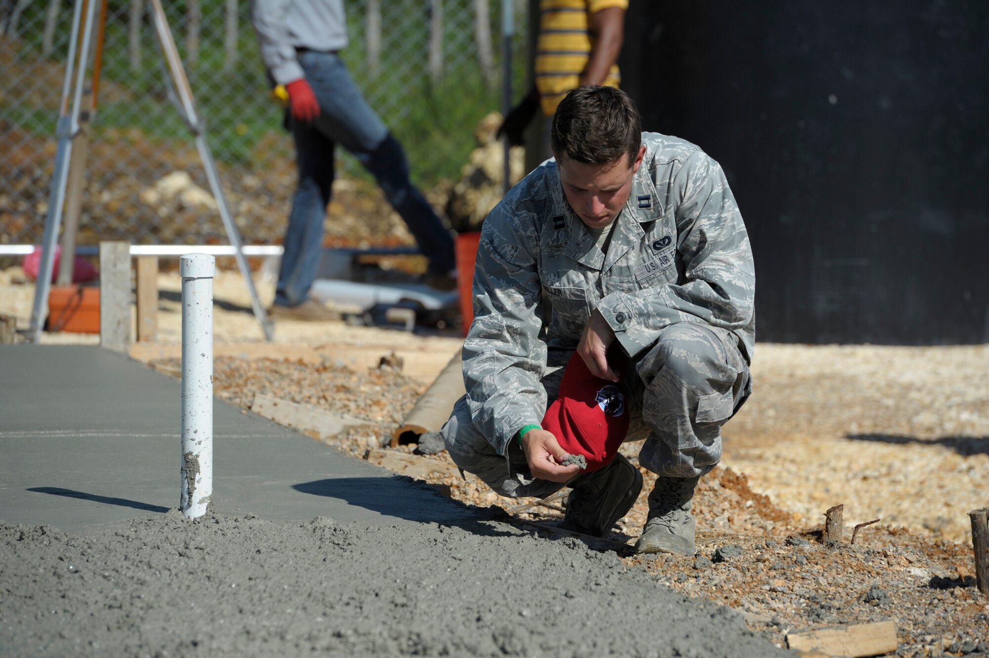 Capt. Joseph Miller, 820th RED HORSE Squadron, quality control officer in charge, checks the consistency of the concrete while local Dominican contractors create a foundation for a new clinic in Copeyito, Dominican Republic as part of Exercise NEW HORIZONS 2016, Apr. 8, 2016. Members of the 820th RED HORSE Squadron, from Nellis Air Force Base, Nevada, provide Quality Control and Quality Assurance during the foundation preparation. (U.S. Air Force photo by Master Sgt. Chenzira Mallory/Released)
