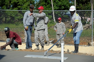 Capt. Joseph Miller, 820th RED HORSE Squadron, quality control officer in charge, coordinates with a local contractor to make adjustments to a new concrete foundation for a clinic being built in Copeyito, Dominican Republic as part of Exercise NEW HORIZONS 2016, Apr. 7, 2016. NEW HORIZONS gives U.S. military members the opportunity to deploy, operate, and re-deploy while including the added benefit of working with and learning from our international partners. (U.S. Air Force photo by Master Sgt. Chenzira Mallory/Released)