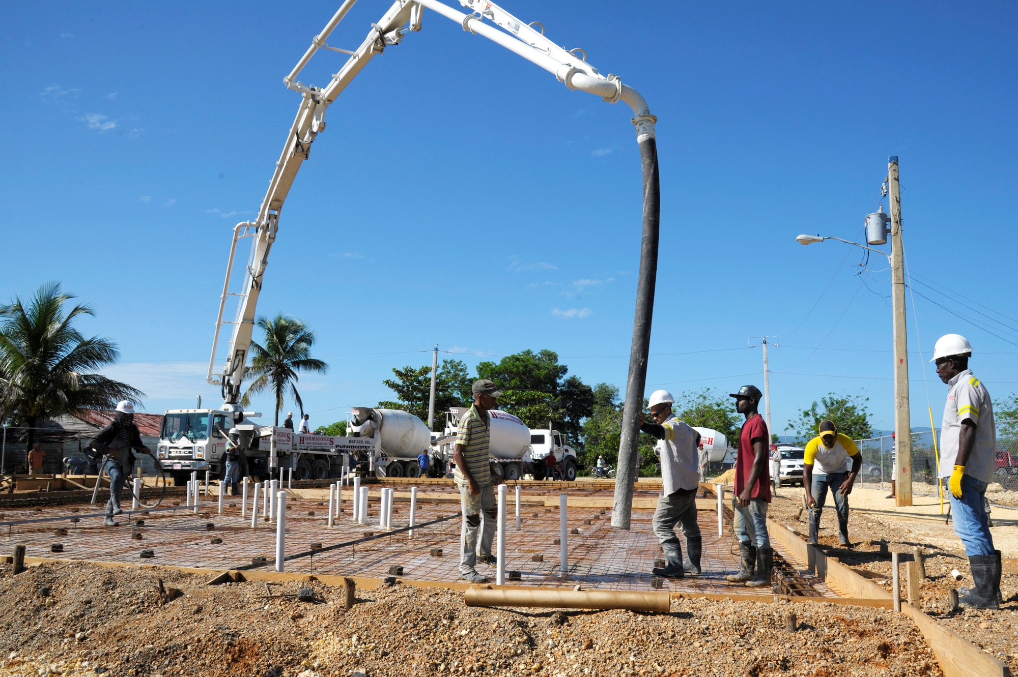 Dominican contractors fill a foundation with concrete for a clinic being built in Copeyito, Dominican Republic as part of Exercise NEW HORIZONS 2016, Apr. 7, 2016. NEW HORIZONS provides essential training to U.S. forces and allows them to remain prepared for real-world deployments in support of contingency, humanitarian assistance and disaster relief operations. (U.S. Air Force photo by Master Sgt. Chenzira Mallory/Released)
