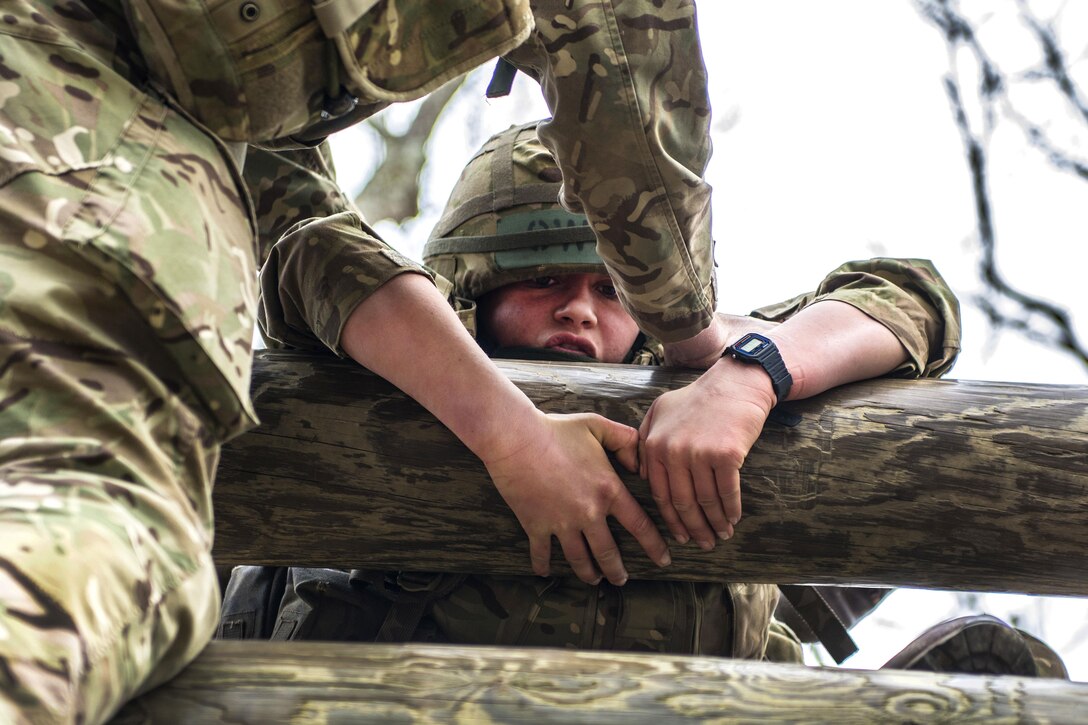 Officer Cadet Perry Georgina Edwards receives a helping hand while practicing the log crawl before the 2016 Sandhurst competition at the U.S. Military Academy, West Point, N.Y., April 6, 2016. Edwards is assigned to the Royal Military Academy Sandhurst, United Kingdom. Army photo by Sgt. 1st Class Brian Hamilton