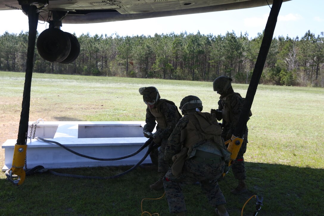 Landing support specialists with Combat Logistics Battalion 6, Transportation Support Battalion, prepare to connect cargo to hooks attached to a CH-53E Super Stallion at landing zone Phoenix, Camp Davis, North Carolina, April 6, 2016. The purpose of external lifts is to transport larger amounts of supplies and heavy gear where other ground vehicles can’t access. (U.S. Marine Corps photo by Lance Cpl. Aaron Fiala/Released.)