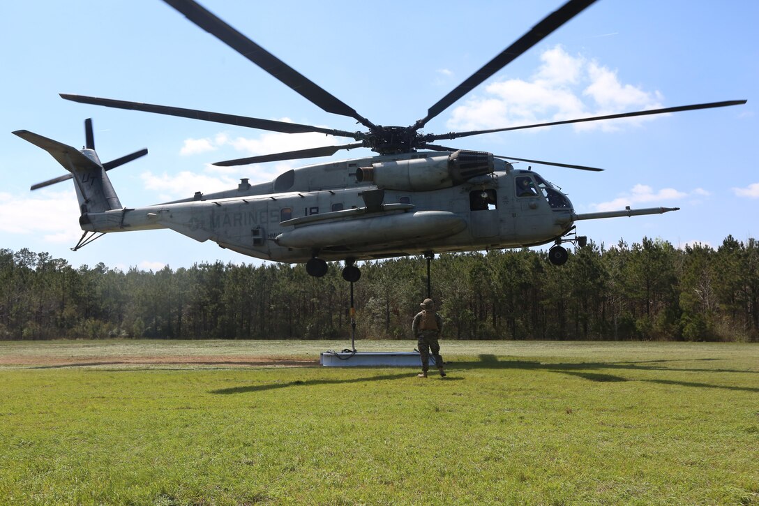 Marines with Marine Heavy Helicopter Training Squadron 302 wait aboard a CH-53E Super Stallion for signals from a Combat Logistics Battalion 6, Transportation Support Battalion, landing support specialist, indicating it is safe to take off with the cargo, during external lifts at landing zone Phoenix, Camp Davis, North Carolina, April 6, 2016. The purpose of external lifts is to transport larger amounts of supplies and heavy gear where other ground vehicles can’t access. (U.S. Marine Corps photo by Lance Cpl. Aaron Fiala/Released.)