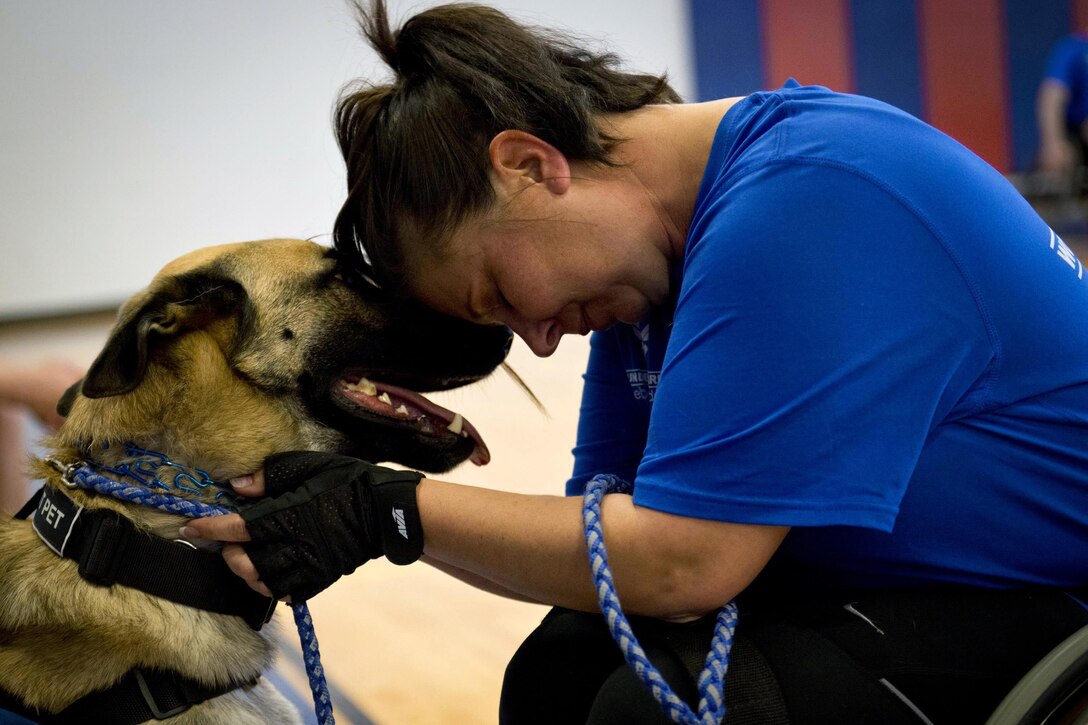 Lisa Hodgden, an Air Force athlete, and her military working dog, Boston, share a moment during a wheelchair basketball session at the adaptive sports camp at Eglin Air Force Base, Fla., April 4, 2016. Air Force photo by Samuel King Jr.