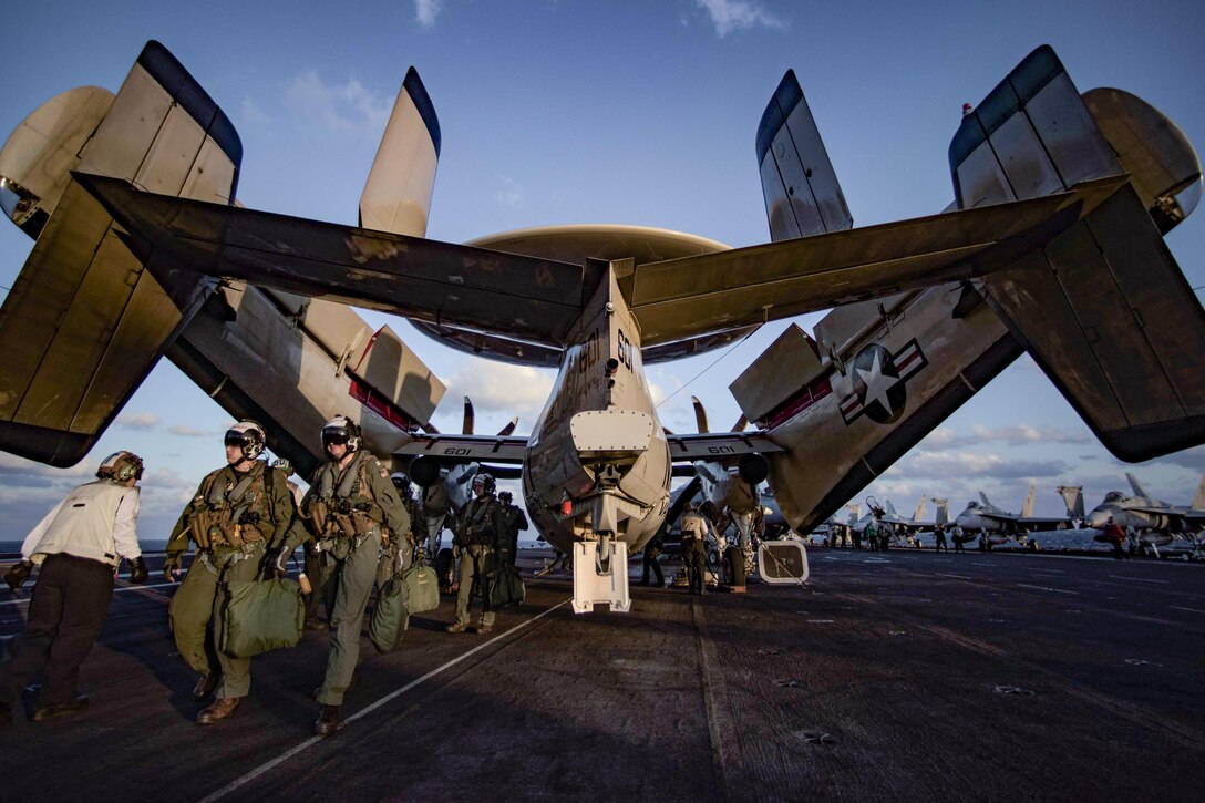 Crew members for a Navy E-2C Hawkeye disembark from the aircraft onto the flight deck of the USS Dwight D. Eisenhower in the Atlantic Ocean, April 5, 2016. The Hawkeye crew is assigned to Carrier Airborne Early Warning Squadron 123. Navy photo by Petty Officer 3rd Class J. Alexander Delgado