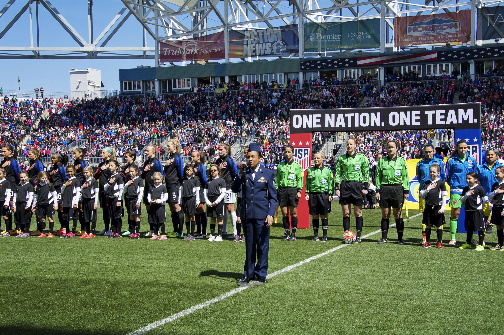 Master Sgt. Shana Wallace, of the 512th Airlift Wing, sings the national anthem before a crowd of 20-thousand fans at Talen Energy Stadium, Chester, Pa., April 10, 2016, before the US Women's Soccer team played Columbia's national soccer team. The friendly competition was the second in a month between the two teams, and the US team won both matches 7-0 and 3-0. 