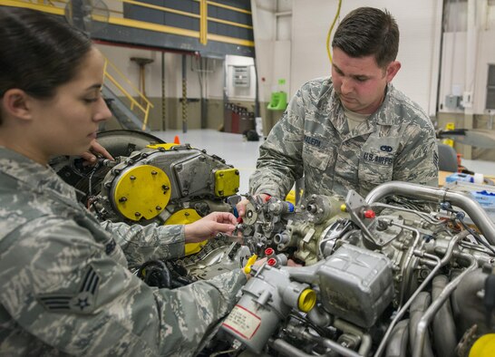 Senior Airmen Natalie Beal and Ryan Nalepa, 919th Special Operations Maintenance Group, perform maintenance on an aircraft engine at Duke Field Fla., Feb. 25.  The Airmen are part of the engine shop within the maintenance group.  (U.S. Air Force photo/Tech. Sgt. Sam King)