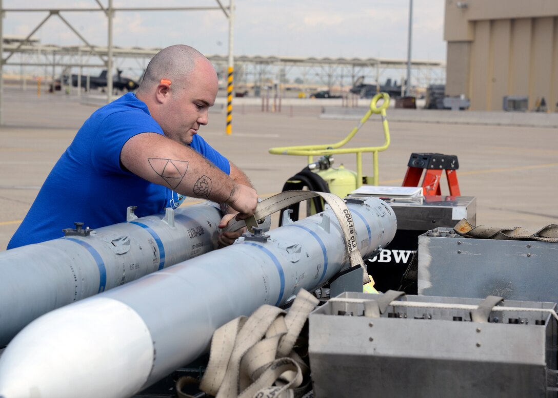 Senior Airman David Davidson, 309th Aircraft Maintenance Unit weapons load crew member, places the belt on an AIM 9 L/M munition during a load crew competition at Luke Air Force Base, Ariz., April 8, 2016. The load crew competition is designed to encourage friendly competition among load crew members and enable them to display the high skill level at which they routinely operate. The purpose of the event is to see which team loads weapons onto their respective aircraft earning the fastest time and the fewest errors.  (U.S. Air Force photo by Senior Airman Devante Williams)