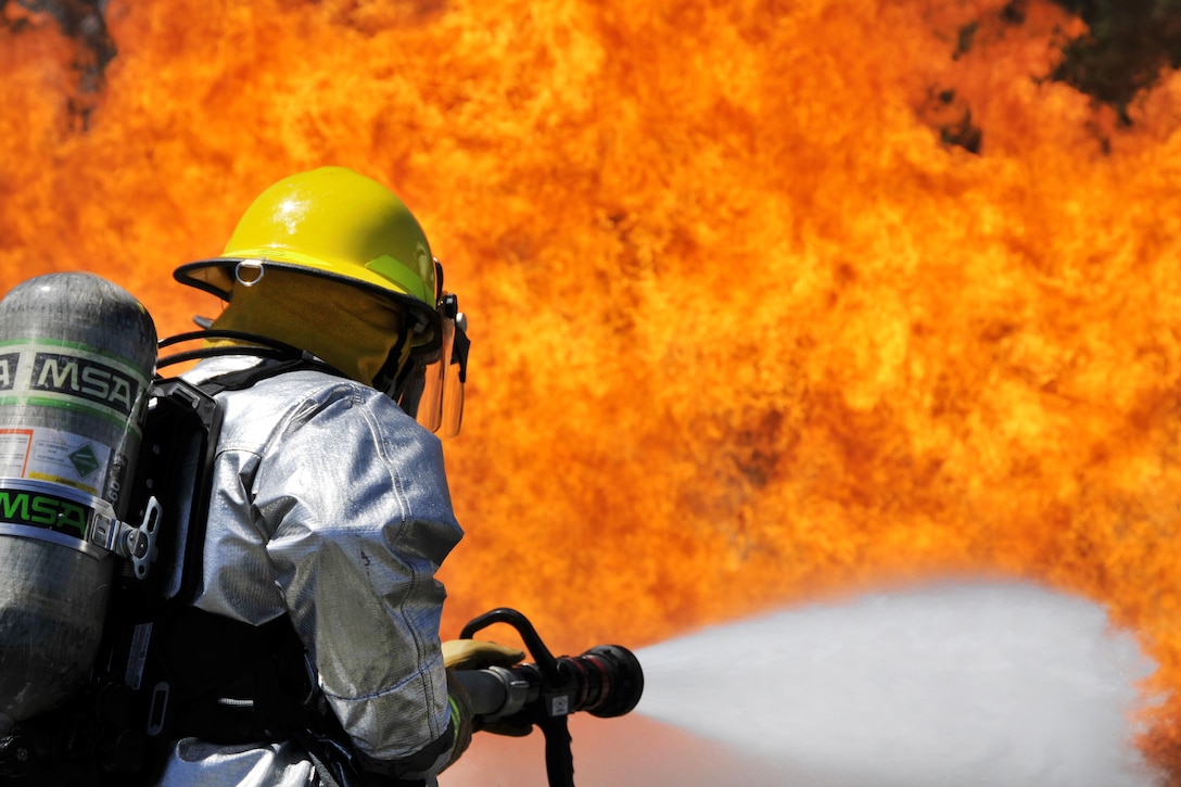 An airman sprays an aircraft training fire at the 165th Airlift Wing's Regional Fire Training Facility in Savannah, Ga., April 4, 2016. Air National Guard photo by Tech. Sgt. Andrew J. Merlock