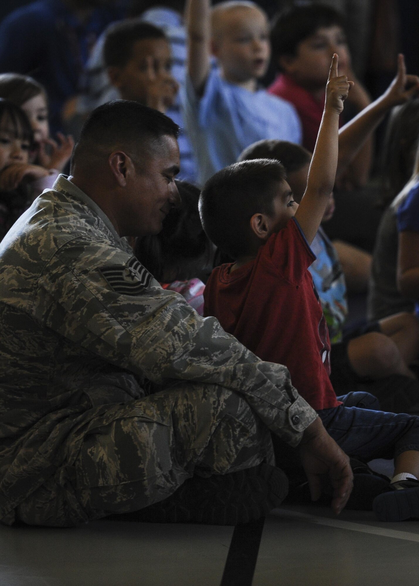 A father and son listen to Lt. Gen. Brad Heithold speak during “Tell me a Story” at the youth center, Hurlburt Field, Fla., April 8, 2016. This reading program , geared toward children ages 4-12, uses literature to empower military children. (U.S. Air Force photo by Senior Airman Meagan Schutter)