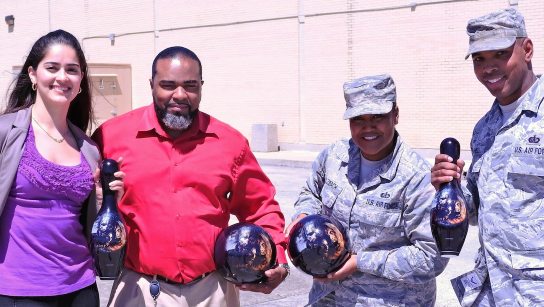 From left, Air Force Services Activity members Andrea Valencia, Corey Davison, Master Sgt. Tunisia Sulzbach and Tech. Sgt. Marcus Darnell show off one side of "Walking Dead" bowling items you'll see as part of the summer league at bowling centers across the Air Force. (U.S. Air Force photo/Steve Warns/Released)
