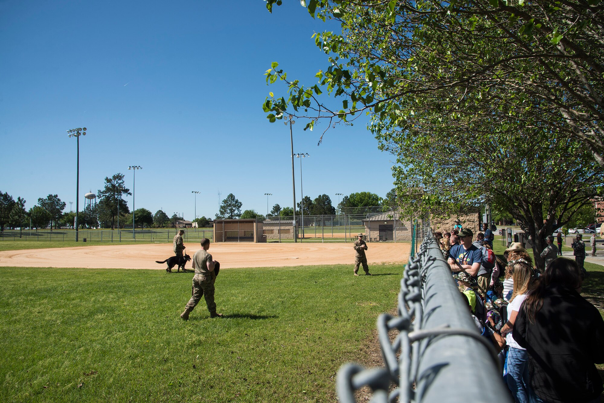 Participants watch a Military Working Dog demonstration during a kids’ deployment line, April 9, 2016, at Moody Air Force Base, Ga. The MWDs performed the six stages of controlled aggression which included a false run, bite and hold, search, escort, standoff and a re-attack. (U.S. Air Force photo by Airman 1st Class Janiqua P. Robinson/Released)