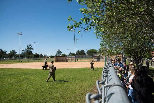 Participants watch a Military Working Dog demonstration during a kids’ deployment line, April 9, 2016, at Moody Air Force Base, Ga. The MWDs performed the six stages of controlled aggression which included a false run, bite and hold, search, escort, standoff and a re-attack. (U.S. Air Force photo by Airman 1st Class Janiqua P. Robinson/Released)