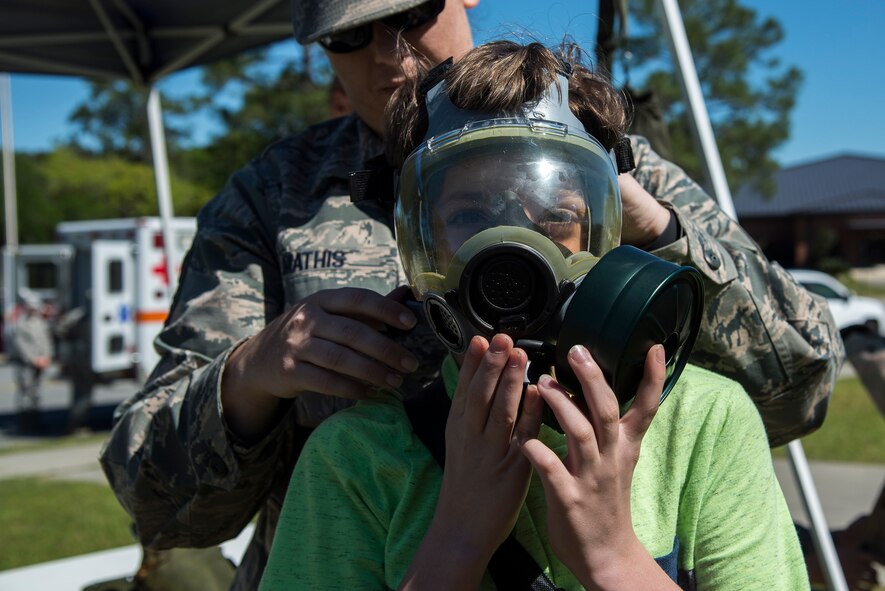Gavin Wainscott, son of U.S. Air Force Staff Sgt. Brandon Wainscott, 822d Base Defense Squadron military working dog handler, dons a gas mask during a kids’ deployment line, April 9, 2016, at Moody Air Force Base, Ga. Participants had the opportunity to try on helmets, vests, gas masks, and even full mission-oriented protective posture gear. (U.S. Air Force photo by Airman 1st Class Janiqua P. Robinson/Released)