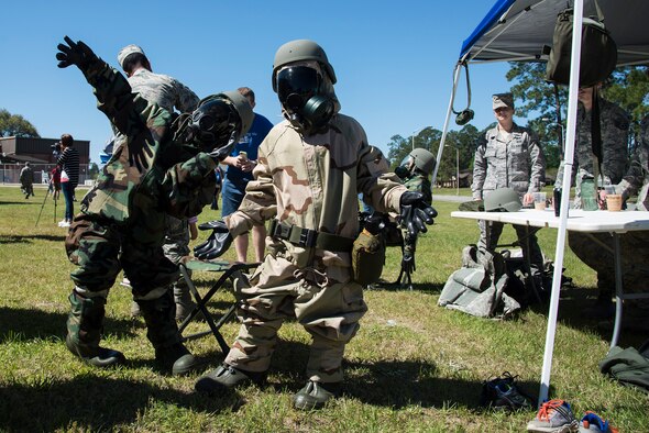 Caleb and Aiden Campbell, sons of U.S. Air Force Tech. Sgt. Lee Campbell, 23d Equipment Maintenance Squadron crew chief, pose for a photo after donning full mission-oriented protective posture gear during a kids’ deployment line, April 9, 2016, at Moody Air Force Base, Ga. MOPP gear is used to protect military personnel in the event of chemical or biological attack. (U.S. Air Force photo by Airman 1st Class Janiqua P. Robinson/Released)