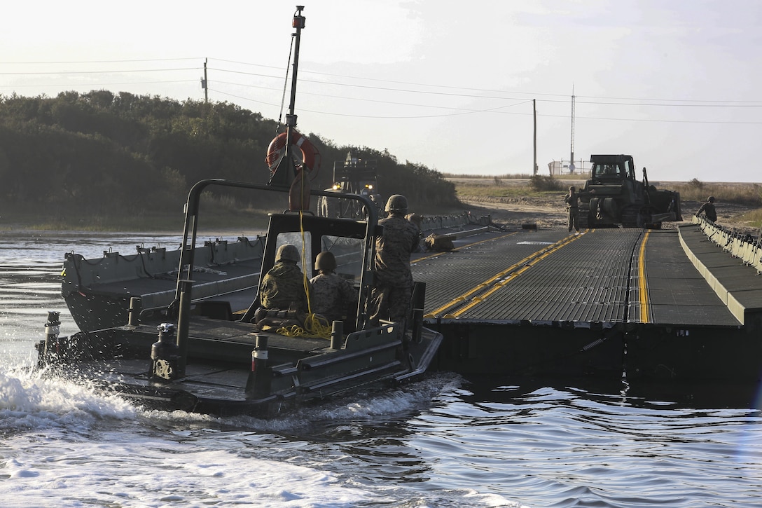 Marines with Bridge Company, 8th Engineer Support Battalion utilize a bridge erection boat to steady a bridge as part of exercise Saipan Rain at Camp Lejeune, N.C., March 30, 2016. The Marines constructed the bridge to allow Marines, vehicles, and equipment, with 10th and 14th Marine Regiments to conduct a water gap crossing. (U.S. Marine Corps photo by Cpl. Paul S. Martinez/Released)