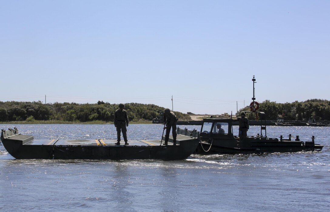 Marines with Bridge Company, 8th Engineer Support Battalion utilize a bridge erection boat to move a water bay during the set-up of a water-crossing bridge as part of exercise Saipan Rain at Camp Lejeune, N.C., March 30, 2016. The Marines constructed the bridge to allow Marines, vehicles, and equipment, with 10th and 14th Marine Regiments to conduct a water gap crossing. (U.S. Marine Corps photo by Cpl. Paul S. Martinez/Released)