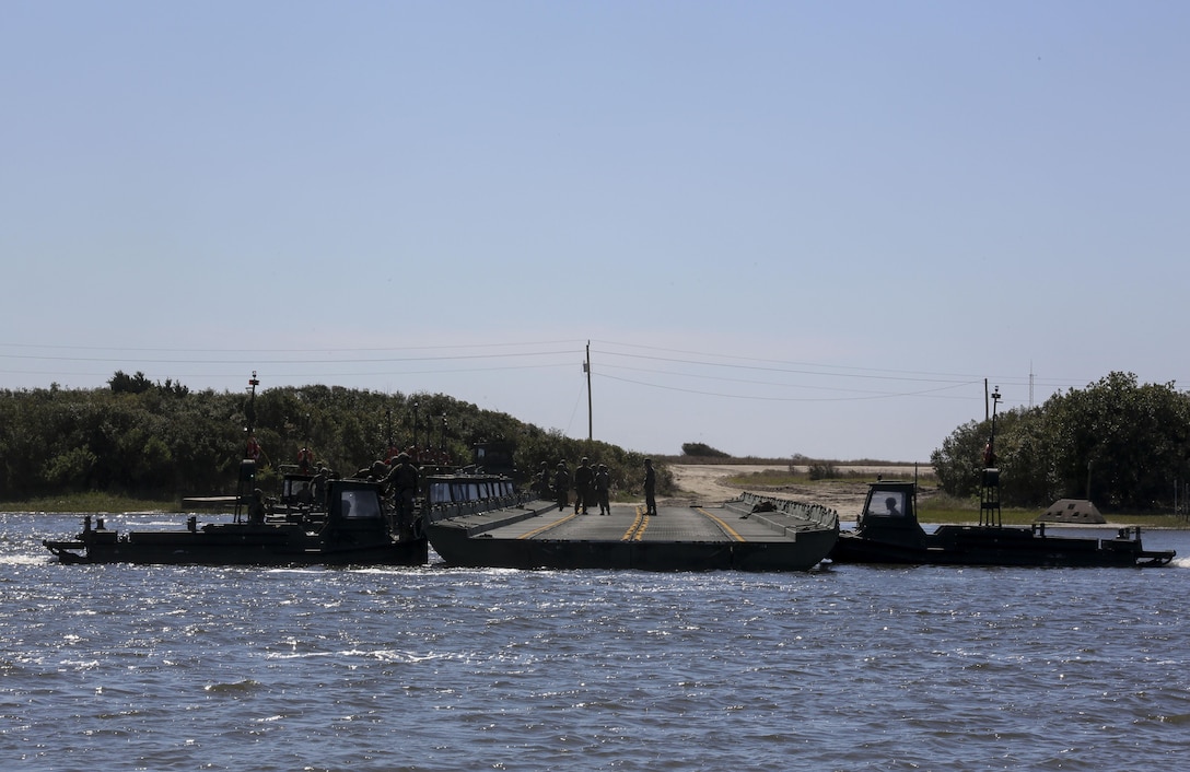 Marines with Bridge Company, 8th Engineer Support Battalion utilize a bridge erection boat to move a series of connected water bays during the set-up of a water-crossing bridge as part of exercise Saipan Rain at Camp Lejeune, N.C., March 30, 2016. The Marines constructed the bridge to allow Marines, vehicles, and equipment, with 10th and 14th Marine Regiments to conduct a water gap crossing. (U.S. Marine Corps photo by Cpl. Paul S. Martinez/Released)
