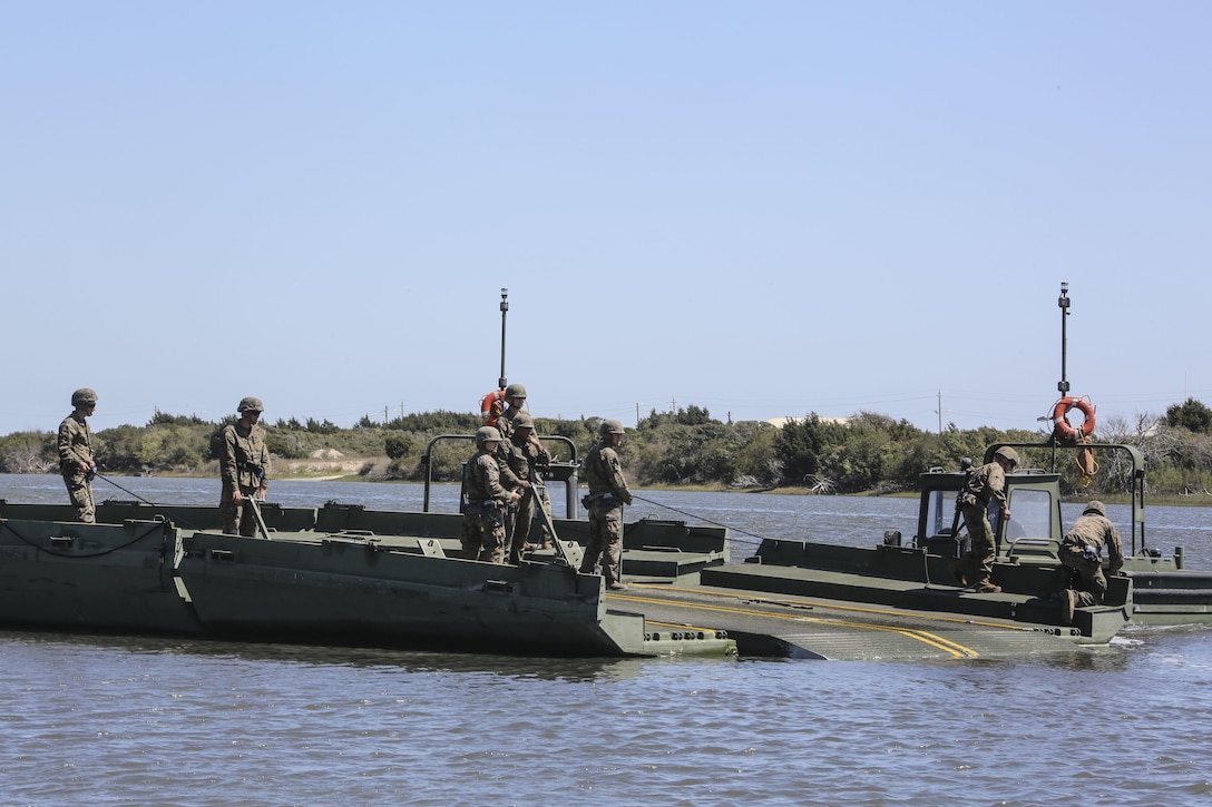 Marines with Bridge Company, 8th Engineer Support Battalion prepare to connect two water bays during the set-up of a water-crossing bridge as part of exercise Saipan Rain at Camp Lejeune, N.C., March 30, 2016. The company’s capability to construct a bridge over a body of water allows Marines and vehicles to travel to destinations that may otherwise be unreachable. (U.S. Marine Corps photo by Cpl. Paul S. Martinez/Released)