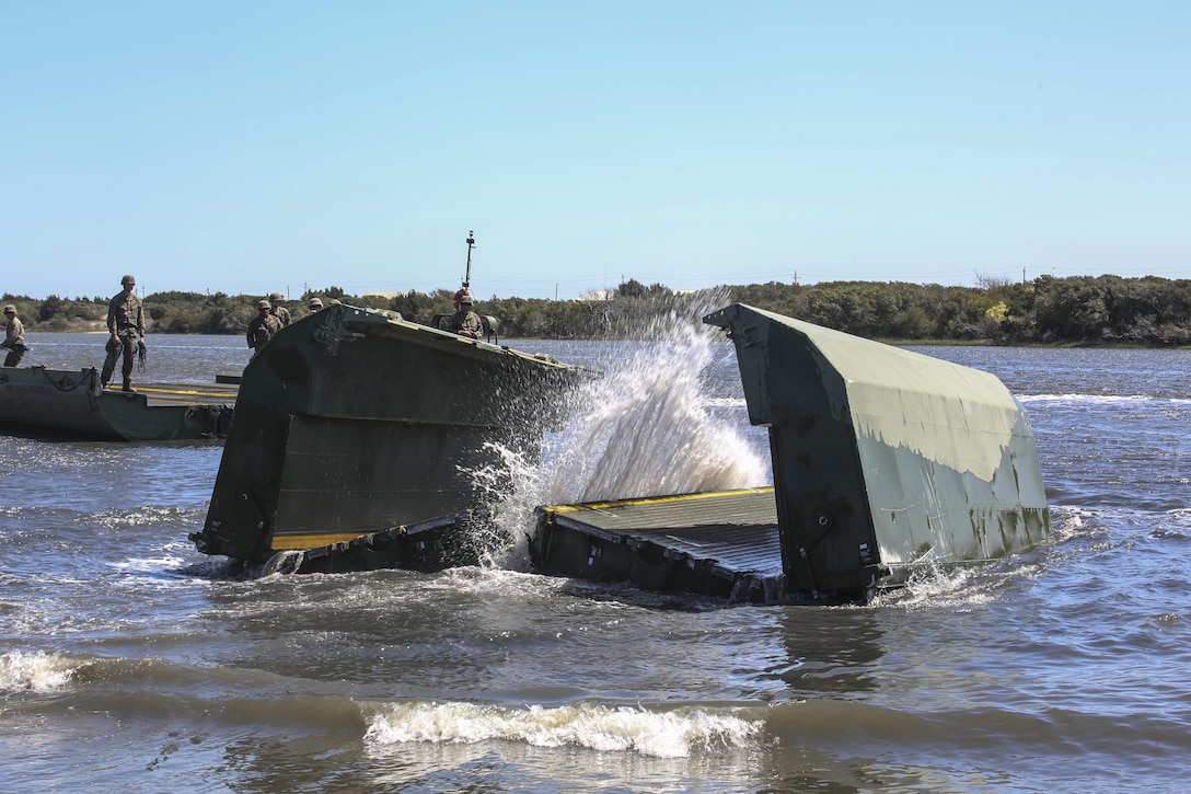 A water bay dropped by Marines with Bridge Company, 8th Engineer Support Battalion unfolds upon impact during the set-up of a water-crossing bridge as part of exercise Saipan Rain at Camp Lejeune, N.C., March 30, 2016. The Marines constructed the bridge to allow Marines, vehicles, and equipment, with 10th and 14th Marine Regiments to conduct a water gap crossing. (U.S. Marine Corps photo by Cpl. Paul S. Martinez/Released)