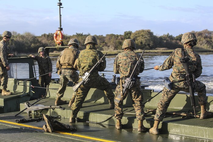 Marines with Bridge Company, 8th Engineer Support Battalion pull a cable to secure a bridge bay during construction as part of exercise Saipan Rain at Camp Lejeune, N.C., March 30, 2016. The Marines constructed the bridge to allow Marines, vehicles, and equipment, with 10th and 14th Marine Regiments to conduct a water gap crossing. (U.S. Marine Corps photo by Cpl. Paul S. Martinez/Released)