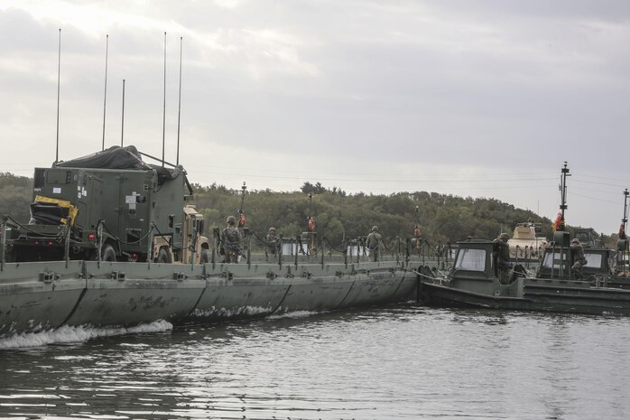 A convoy of vehicles and equipment with 10th Marine Regiment cross a bridge constructed by Marines with Bridge Company, 8th Engineer Support Battalion, as part of exercise Saipan Rain at Camp Lejeune, N.C., March 31, 2016. The company’s capability to construct a bridge over a body of water allows Marines and vehicles to travel to destinations that may otherwise be unreachable. (U.S. Marine Corps photo by Cpl. Paul S. Martinez/Released)