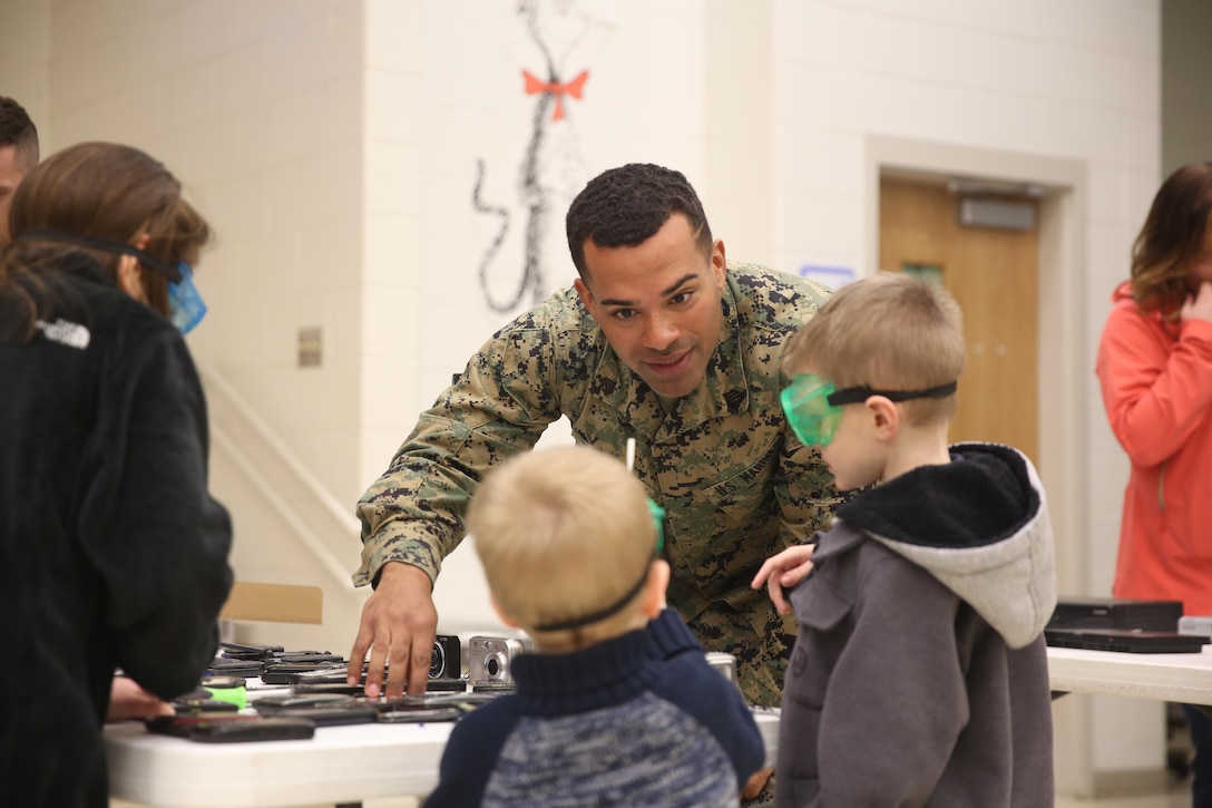 Sgt. Rakiem Bailey, an automotive maintenance technician with 2nd Radio Battalion, helps students learn about reverse engineering during the Science, Technology, Engineering and Math Carnival at Johnson Primary School on Marine Corps Base Camp Lejeune Friday. Bailey was one of nearly 80 volunteers for this event that showcased what students have been learning through the STEM program.