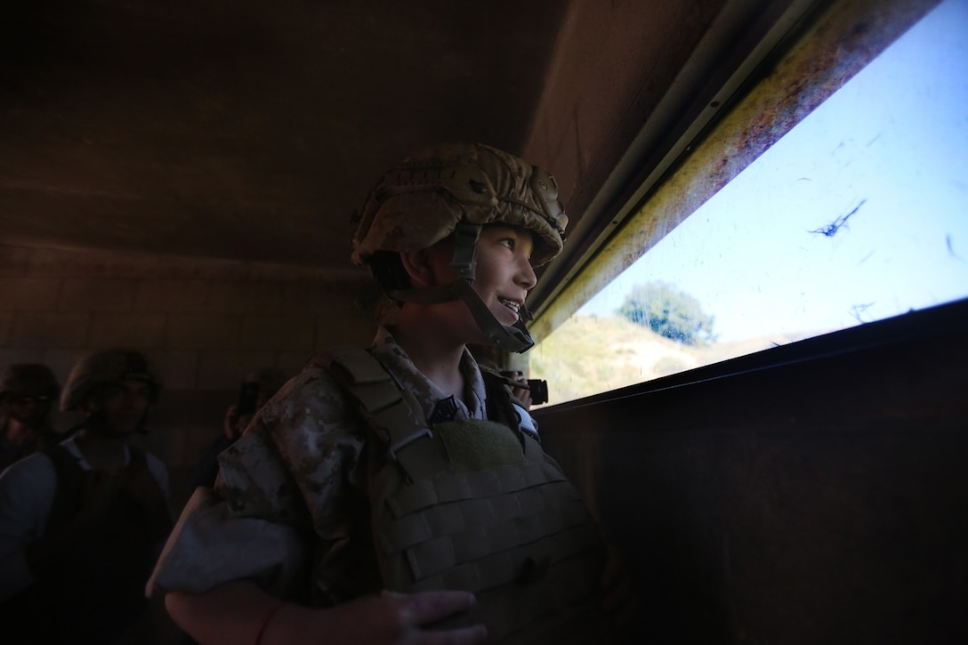 Nathan Aldaco, a 12 year-old boy with hypoplastic left heart syndrome, looks out of a bunker during a Make-A-Wish event supported by 7th Engineer Support Battalion, 1st Marine Logistics Group, aboard Camp Pendleton, Calif., March 24, 2016. Marines with 7th ESB and Explosive Ordnance Disposal helped to make Nathan’s wish of becoming a Marine come true by demonstrating the capabilities of their EOD robots and detonating TNT, C4, dynamite and blasting caps, while the heavy equipment operators gave him the opportunity to ride the D7 dozer and the excavator, in which he dug a pit, built a berm, and broke several large tree trunks.  (U.S. Marine Corps photo by Sgt. Laura Gauna/released)