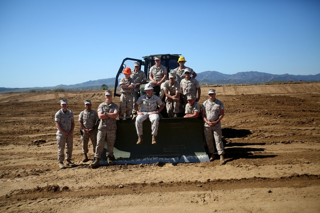 Nathan Aldaco, a 12 year-old boy with hypoplastic left heart syndrome, poses for a photo with heavy equipment operators during a Make-A-Wish event supported by 7th Engineer Support Battalion, 1st Marine Logistics Group, aboard Camp Pendleton, Calif., March 24, 2016. Marines with 7th ESB and Explosive Ordnance Disposal helped to make Nathan’s wish of becoming a Marine come true by demonstrating the capabilities of their EOD robots and detonating TNT, C4, dynamite and blasting caps, while the heavy equipment operators gave him the opportunity to ride the D7 dozer and the excavator, in which he dug a pit, built a berm, and broke several large tree trunks.  (U.S. Marine Corps photo by Sgt. Laura Gauna/released)