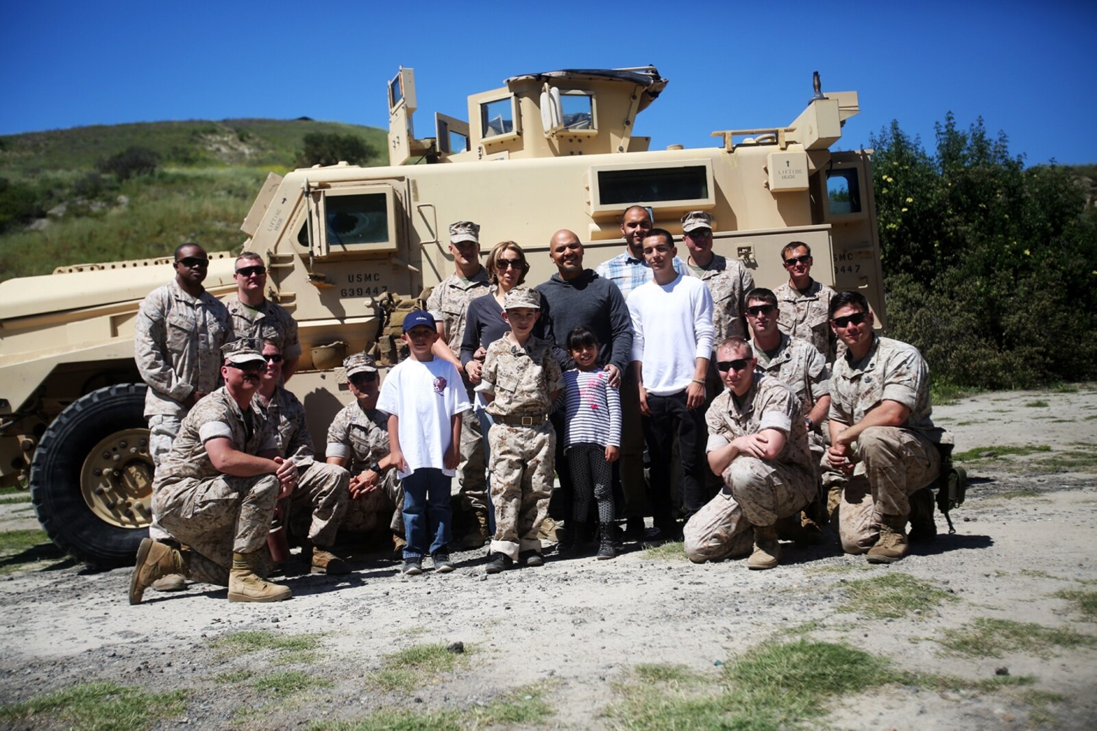 Nathan Aldaco, a 12 year-old boy with hypoplastic left heart syndrome, and his family, pose for a picture with Explosive Ordnance Disposal Marines during a Make-A-Wish event supported by 7th Engineer Support Battalion, 1st Marine Logistics Group, aboard Camp Pendleton, Calif., March 24, 2016. Marines with 7th ESB and Explosive Ordnance Disposal helped to make Nathan’s wish of becoming a Marine come true by demonstrating the capabilities of their EOD robots and detonating TNT, C4, dynamite and blasting caps, while the heavy equipment operators gave him the opportunity to ride the D7 dozer and the excavator, in which he dug a pit, built a berm, and broke several large tree trunks. (U.S. Marine Corps photo by Sgt. Laura Gauna/released)