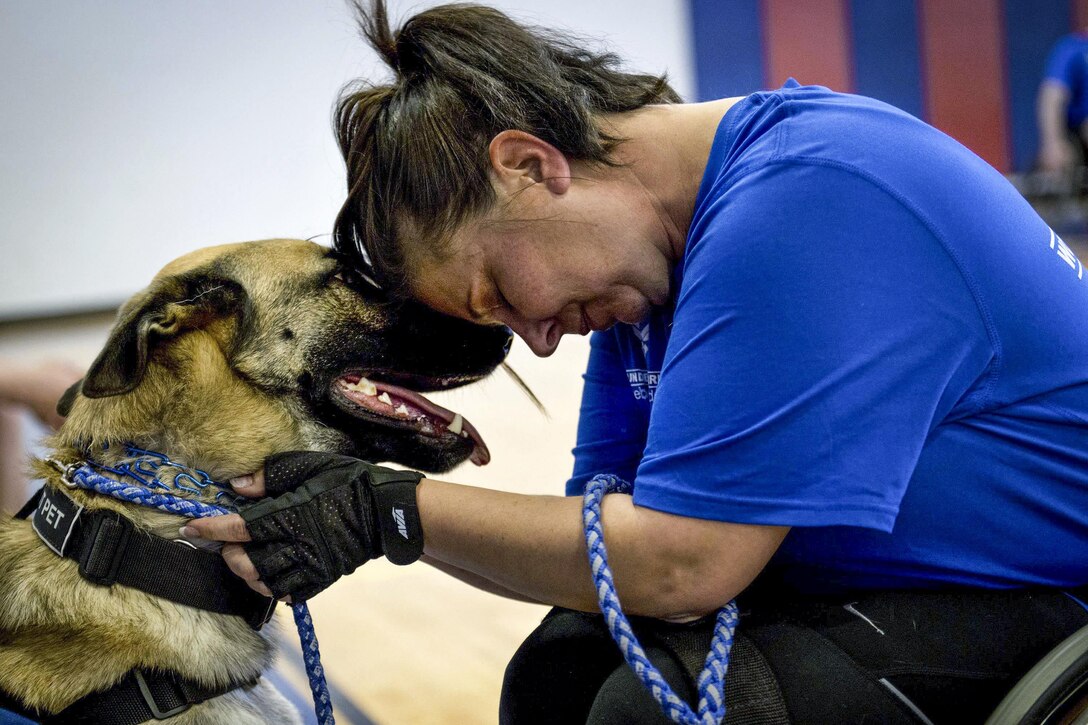 Lisa Hodgden, an Air Force athlete, and her military working dog, Boston, share a moment during a wheelchair basketball session at the adaptive sports camp at Eglin Air Force Base, Fla., April 4, 2016. Air Force photo by Samuel King Jr.