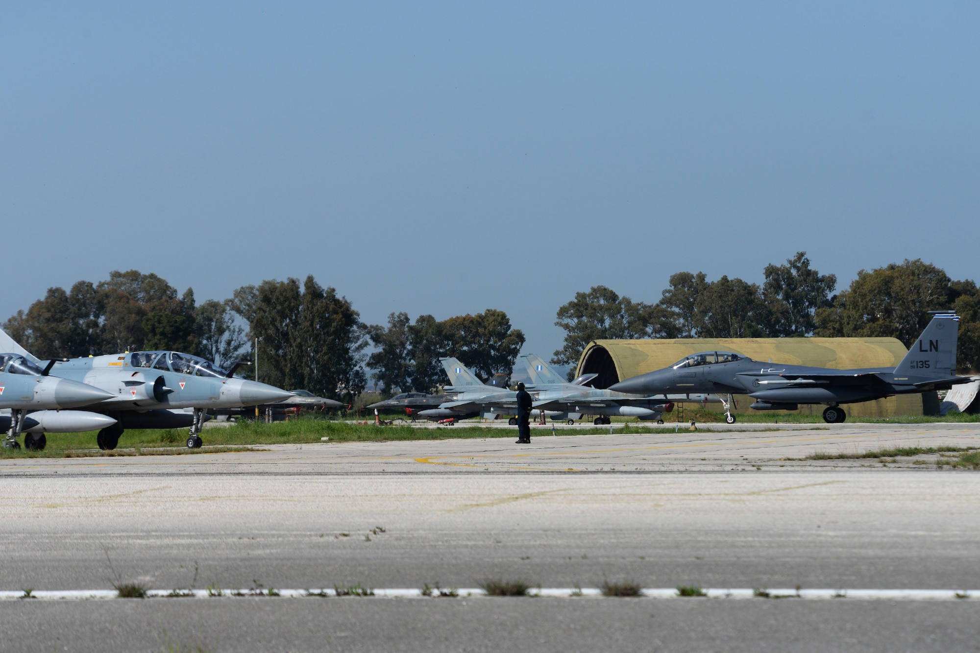 An F-15E Strike Eagle from the 492nd Fighter Squadron, Royal Air Force Lakenheath, England, taxis to the runway past Hellenic Air Force aircraft, April 6, 2016, during exercise INIOHOS 16 at Andravida Air Base, Greece. INIOHOS 16 is a Hellenic air force-hosted air exercise that enhances interoperability, capabilities, and skills amongst allied and partner air forces. (U.S. Air Force photo by Tech. Sgt. Eric Burks/Released)