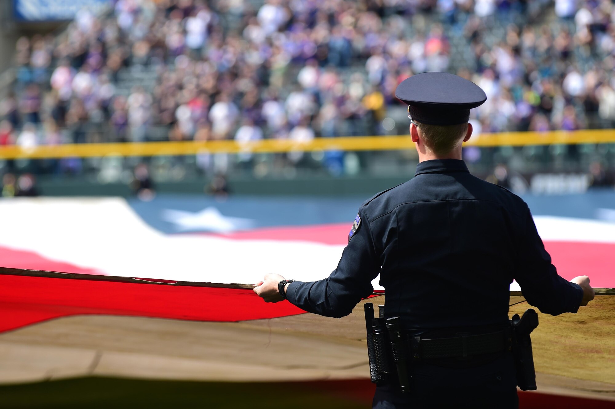 The Colorado Rockies held a military appreciation day April 8, 2016, during pre-game festivities at Coors Field in Denver, Colo. All branches of the military and the community’s civil servants, to include the police department and the county sheriff’s office, attended and participated in the day-long event. The ceremony included a joint color guard and a flag held by those in uniform. (U.S. Air Force photos by Airman 1st Class Gabrielle Spradling/Released)
