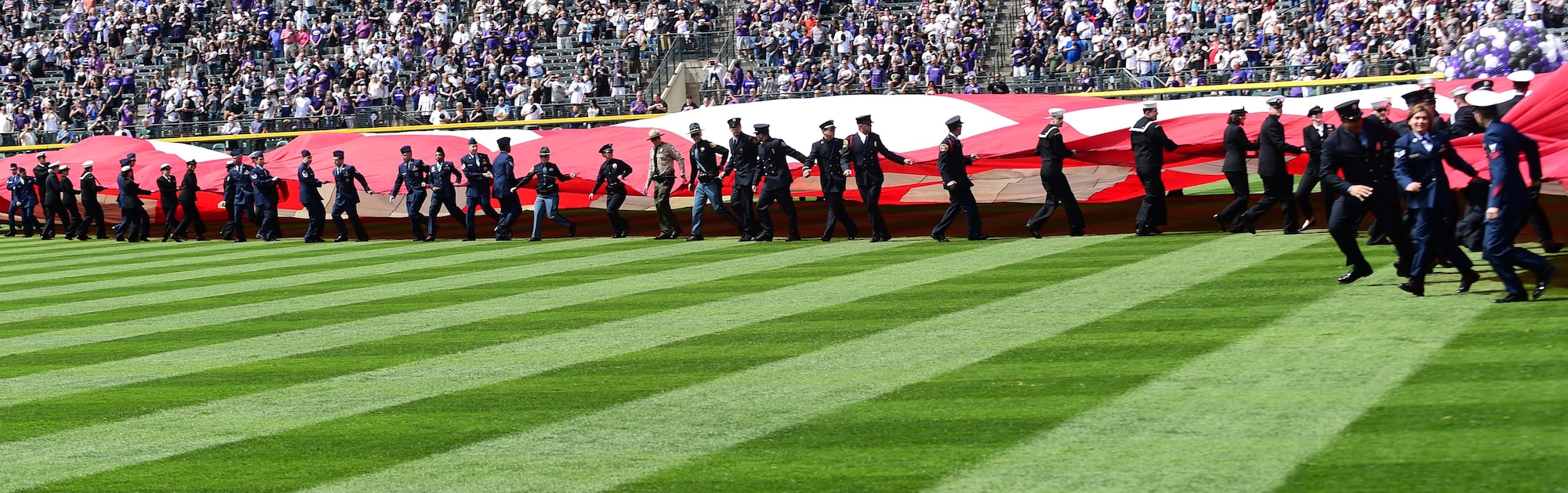 The Colorado Rockies held a military appreciation day April 8, 2016, during pre-game festivities at Coors Field in Denver, Colo. All branches of the military and the community’s civil servants, to include the police department and the county sheriff’s office, attended and participated in the day-long event. The ceremony included a joint color guard and a flag held by those in uniform. (U.S. Air Force photos by Airman 1st Class Gabrielle Spradling/Released)