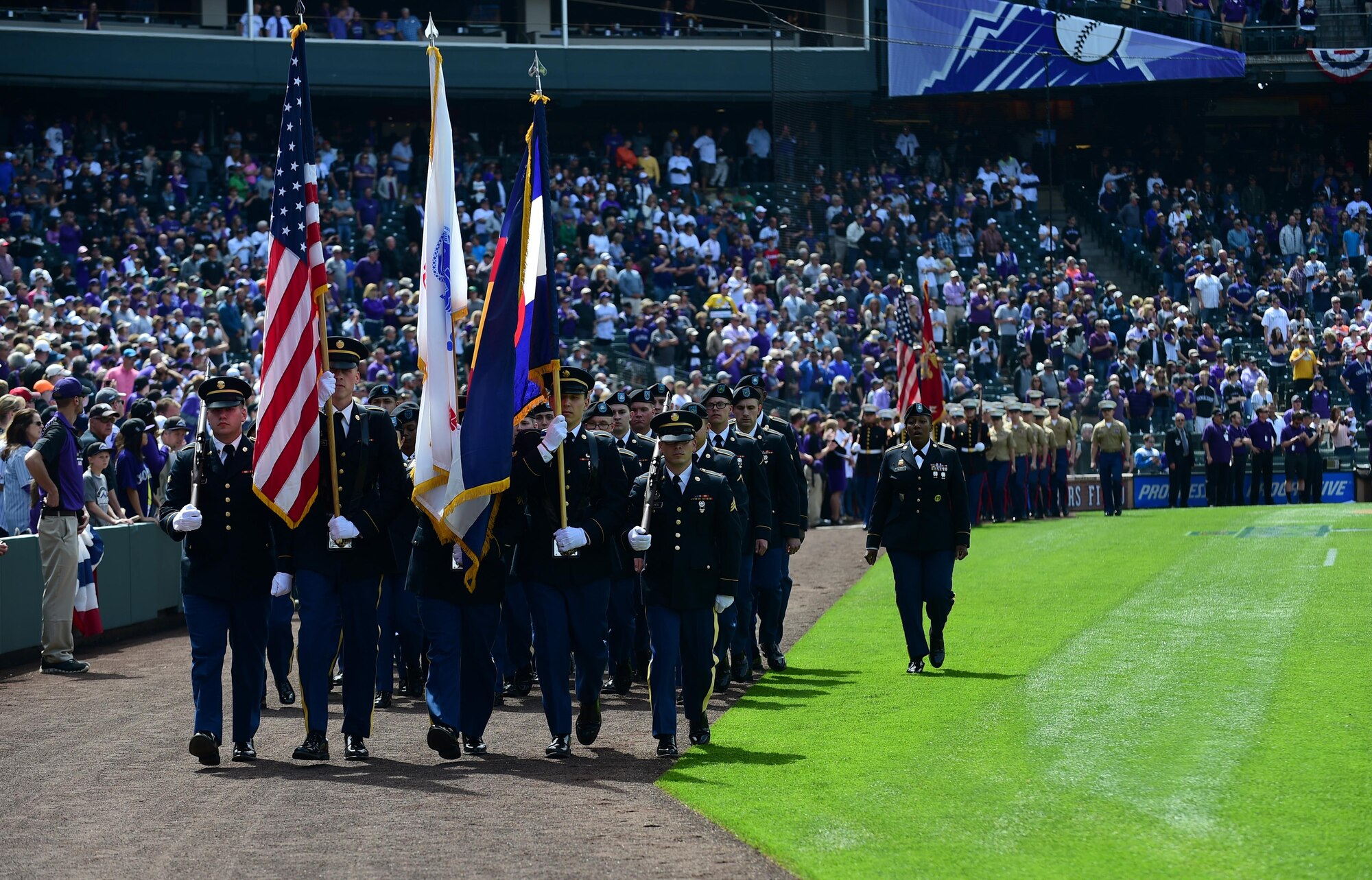 The Colorado Rockies held a military appreciation day April 8, 2016, during pre-game festivities at Coors Field in Denver, Colo. All branches of the military and the community’s civil servants, to include the police department and the county sheriff’s office, attended and participated in the day-long event. The ceremony included a joint color guard and a flag held by those in uniform. (U.S. Air Force photos by Airman 1st Class Gabrielle Spradling/Released)