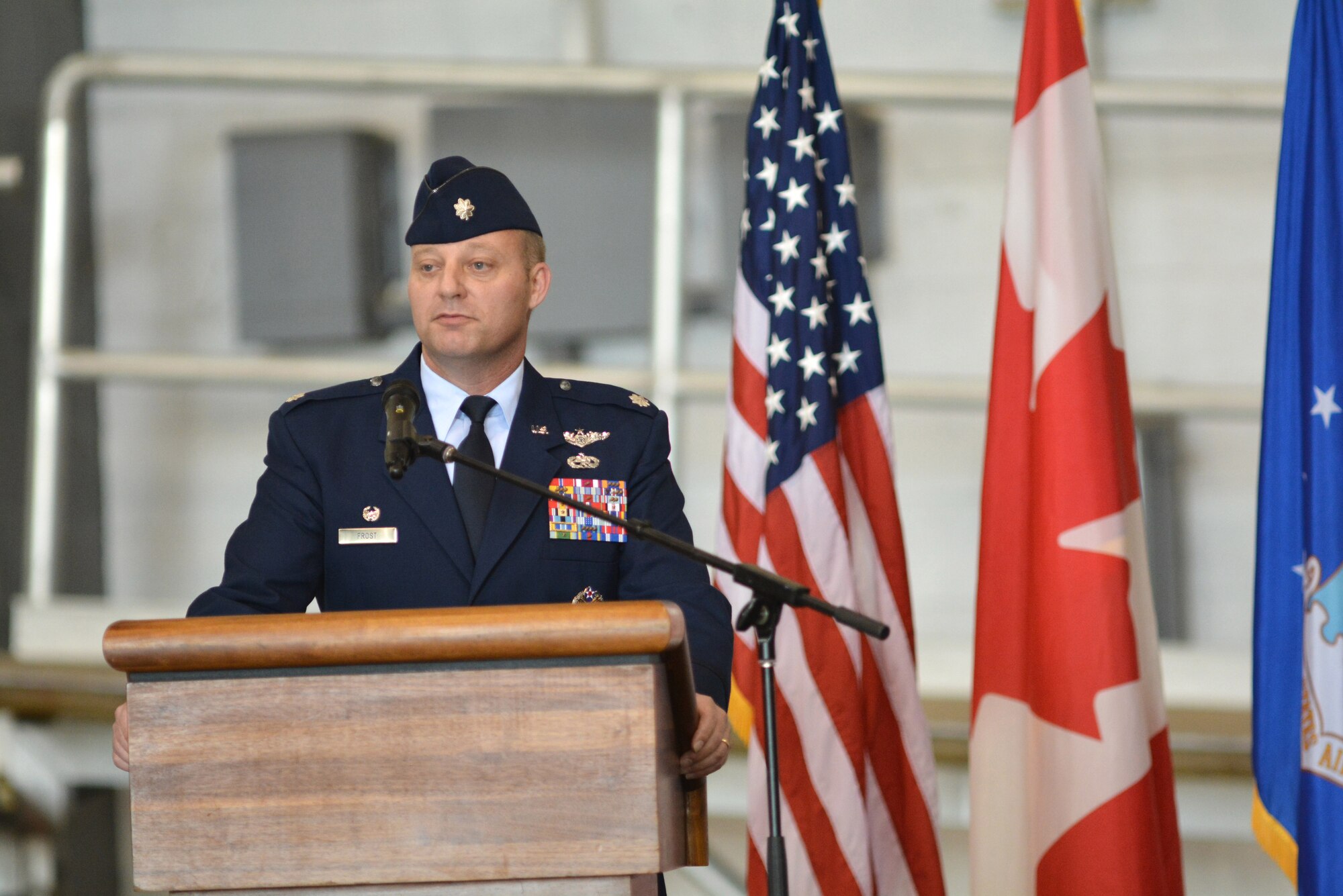 Lt. Col. Wayne Frost addresses a crowd of family, friends and co-workers for the very first time shortly after assuming command of the 963rd Airborne Air Control Squadron in an official ceremony March 30 in Bldg. 230, Dock 2. Col. Alain Poisson, 552nd Operations Group commander, presided over the afternoon ceremony. Colonel Frost, who replaces Lt. Col. Tony Alvarado, had previously served as the director of operations for the 964th AACS. (Air Force photo by Darren D. Heusel/Released)