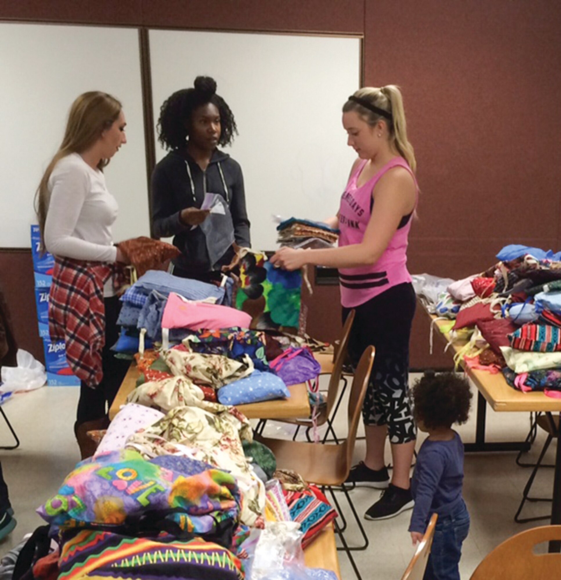 Volunteers from the 377th Medical Group sort hygiene items to prepare kits for girls in Nepal. The MDG joined the non-profit Women to Be to send the hygiene kits to Nepal in an effort to help empower Nepalese girls by providing items that will allow them to stay in school. (Courtesy photo)